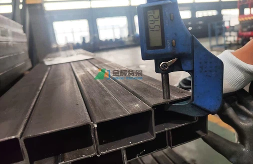 Worker using digital caliper measuring steel racking component for quality control Worker using digital caliper measuring steel racking component for quality control